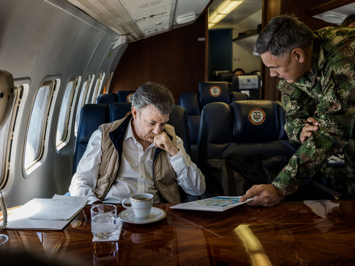 Provinsen Norte Santander: Om bord på presidentens fly. President Santos på vei til Tipú, et av områdene som er sterkest berørt av konflikten. Før landing blir han briefet om sikkerhetssituasjonen på bakken av General Maldonado. © Mads Nissen / Politiken for Nobels Fredssenter