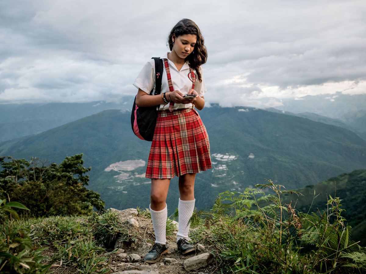 El Orejon, Antioqui-provinsen: Alexandra Mazo (12) med mobiltelefonen sin på vei nedover fjellet etter skolen.Området hun bor i er sterkt berørt av konflikten. Væpnede grupper så vel som narkotikaprodusenter opererer åpenlyst her. © Mads Nissen / Politiken for Nobels Fredssenter